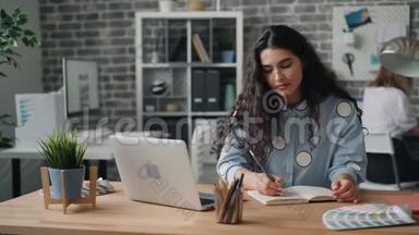 漂亮的年轻女士<strong>在笔记本上写字</strong>，<strong>在</strong>办公室里用<strong>笔记本</strong>电脑工作